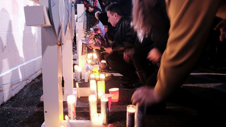 ساکنان کنوشا روز پس از عبور یک خودرو از رژه تعطیلات در ووکشا، ویسکانسین، ایالات متحده، در 22 نوامبر 2021، در مراسم شمع‌افروزی به یاد قربانیان شرکت می‌کنند.