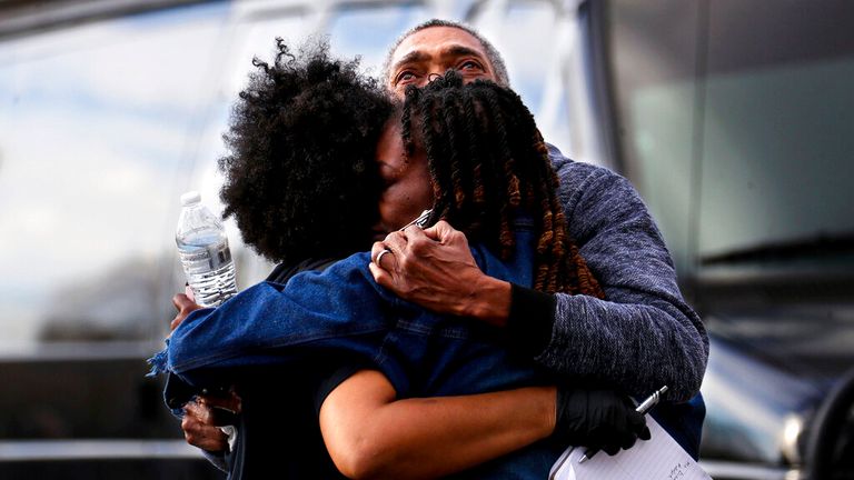 A Memphis police officer hugs the family of rapper Young Dolph after he was shot dead