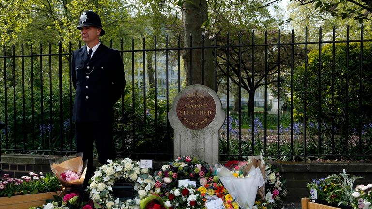 Un officier de police se tient à côté d'hommages floraux lors d'un service commémoratif organisé à St James Square, à Londres, pour marquer le trentième anniversaire de la mort de WPC Yvonne Fletcher