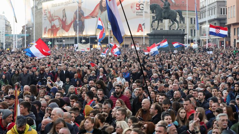 Göstericiler koronavirüs hastalığı (COVID-19) önlemlerini protesto etmek için toplanırken bayraklar taşıyorlar, Hırvatistan, Zagreb'de 20 Kasım 2021