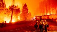 Firefighters work to stop a wildfire spreading to Eldorado National Forest, California in August 2021
