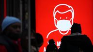 A government digital poster in London encourages people to wear face masks to curb the spread of coronavirus. Pic: AP