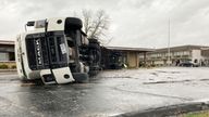 A lorry is flipped over and pushed against a building in Bowling Green, Kentucky. Pic: AP