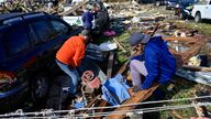 People survey the damage of the home of their grandmother, who was torn from the house and found in the street in Dawson Springs, Kentucky