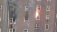 A person can be seen climbing out a window as flames and black smoke also billowed from the building