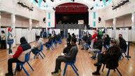 People wait in turn to receive a 'Jingle Jab' Covid vaccination booster injection at Redbridge Town Hall, in Ilford, Essex, as the coronavirus booster programme continues across the UK on Christmas day. Picture date: Thursday December 23, 2021. 
