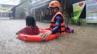 A Philippine Coast Guard personnel assists a resident in their evacuation due to flooding caused by Typhoon Rai in Cagayan De Oro City, Philippines, December 16, 2021. Philippine Coast Guard/ Handout via REUTERS. THIS IMAGE HAS BEEN SUPPLIED BY A THIRD PARTY. NO RESALES. NO ARCHIVES. MANDATORY CREDIT
