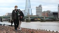 People walk along the River Thames in central London