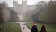 A man wears a Christmas hat as he walks along the Long Walk in front of Windsor Castle in Windsor, Britain, December 24, 2021. REUTERS/Hannah McKay
