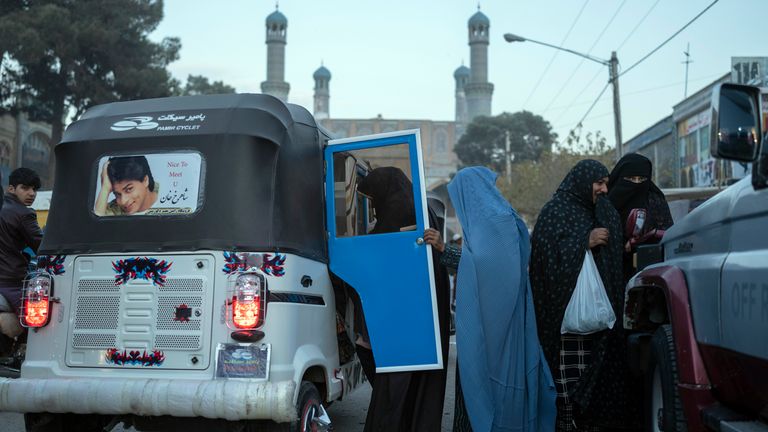 Women in veil get in a three wheel taxi in Herat, Afghanistan. Pic: AP
