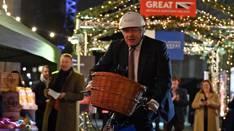 Le Premier ministre Boris Johnson à bicyclette alors qu'il visite un marché britannique d'alimentation et de boissons installé à Downing Street