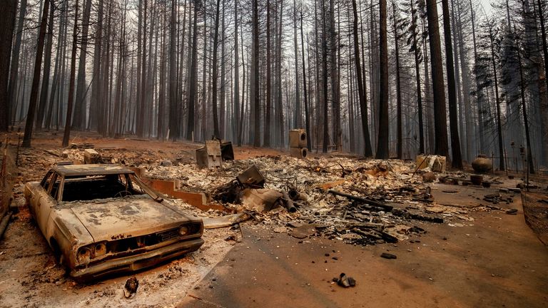 A vehicle and property were destroyed by the Caldor Fire sit in Grizzly Flats, Calif