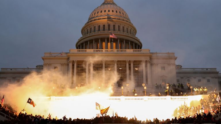 An explosion caused by a police munition is seen while supporters of US President Donald Trump riot in front of the US Capitol Building