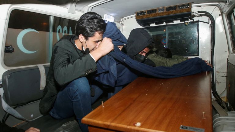 Men react next to the coffin of an Iraqi Kurdish migrant who drowned while trying to cross the channel between France and Britain, at Erbil International Airport, in Erbil, Iraq, December 26, 2021. REUTERS/Azad Lashkari