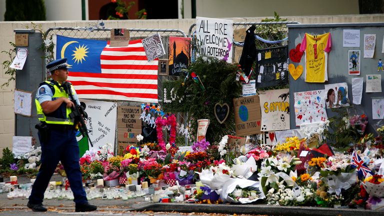 A policeman walks by a memorial to those killed in a terror attack by a white supremacist in Christchurch, New Zealand in 2019. REUTERS/Edgar Su