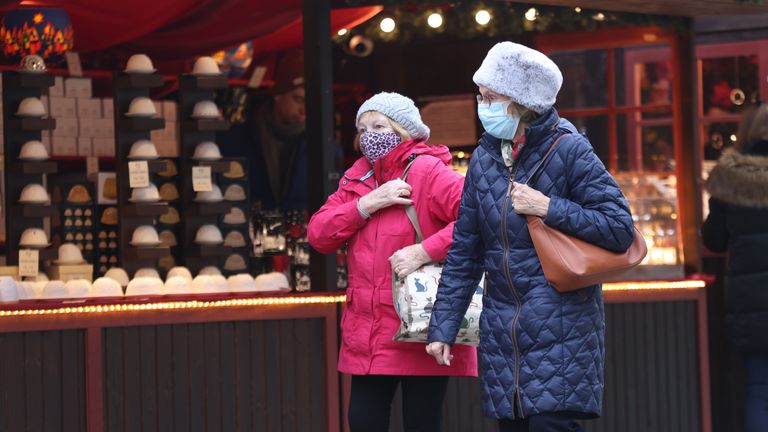 Two women walk in the Christmas market in Trafalgar Square, central London. New restrictions have come into force to slow the spread of the Omicron variant of coronavirus. Picture date: Wednesday December 15, 2021.
