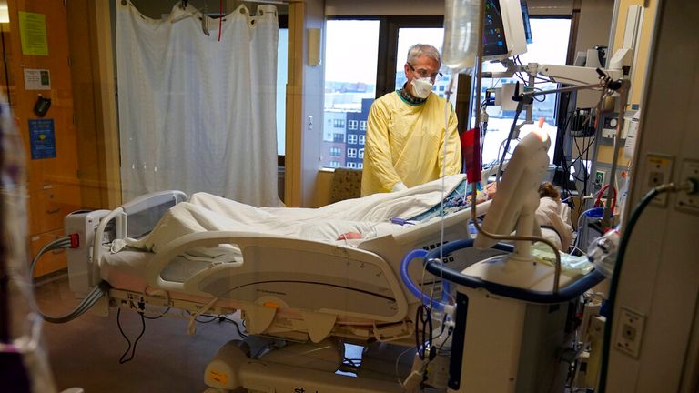 Steve Grove, a chaplain at Hennepin County Medical Center, prays in a COVID-19 patient in Minneapolis. Pic: AP           