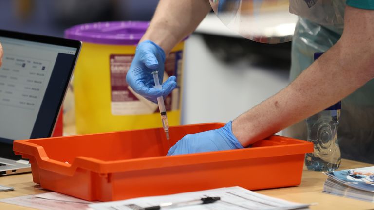 A vaccinator prepares vaccines at a COVID-19 booster vaccination centre at the Titanic Exhibition Centre in Belfast