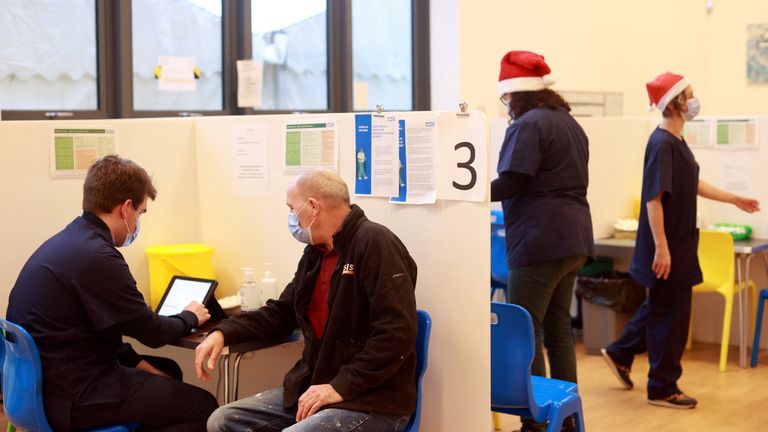 مردی در کریسمس در ایستبورن، بریتانیا، ۲۵ دسامبر ۲۰۲۱، واکسن کروناویروس (COVID-19) را در مرکز جامعه بندر سوپرین دریافت می‌کند. رویترز / هانا مک‌کی
