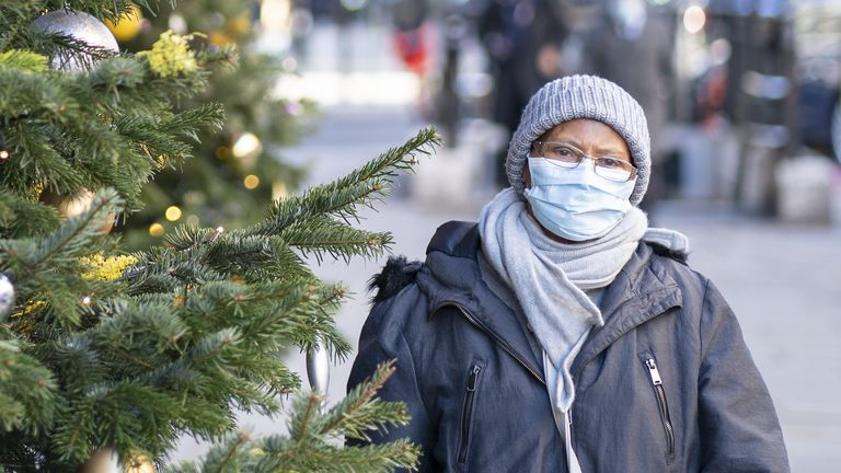 A woman wears a mask as she walks past Christmas decorations in London&#39;s Knightbridge - one of the UK capital&#39;s prime residential and retail areas. Picture date: Thursday December 2, 2021.
