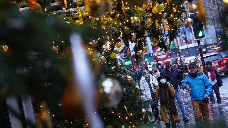 Christmas Eve shoppers walk past festive decorations in Knightsbridge, London, as the government refused to rule out introducing further restrictions to slow the spread of the Omicron variant of coronavirus Picture date: Friday December 24, 2021.

