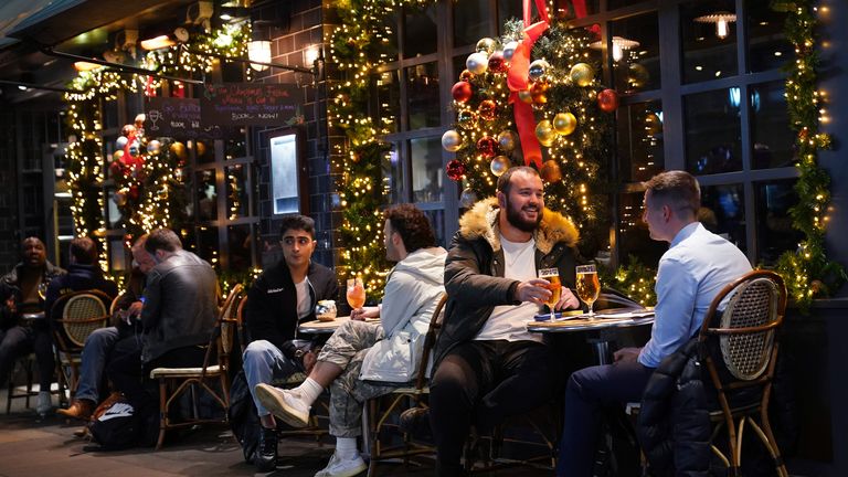 Des personnes buvant devant un bar à Soho, à Londres, où de nouvelles restrictions sont entrées en vigueur pour ralentir la propagation de la variante Omicron du coronavirus.  Photo date : mercredi 15 décembre 2021.