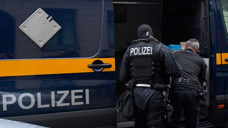 Police in front of a vehicle during raids in several locations in Dresden, Germany, December 15, 2021, as part of an investigation into what they said was a plot to murder the state&#39;s prime minister, Michael Kretschmer, by anti-vaccination activists. The searches in the city of Dresden targeted individual members of a group on the messaging program Telegram, where plans for the killing were discussed in connection with the state government&#39;s coronavirus curbs, police said. 