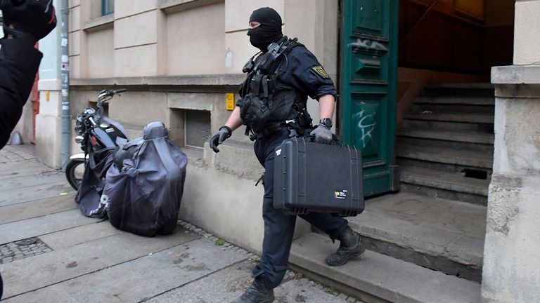 Police leaves a building during raids in several locations in Dresden, Germany, December 15, 2021, as part of an investigation into what they said was a plot to murder the state&#39;s prime minister, Michael Kretschmer, by anti-vaccination activists. The searches in the city of Dresden targeted individual members of a group on the messaging program Telegram, where plans for the killing were discussed in connection with the state government&#39;s coronavirus curbs, police said.  