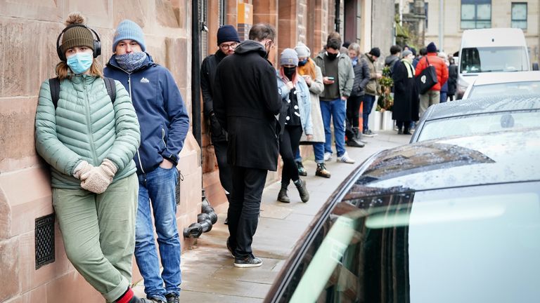 People queue along Junction Place, Edinburgh, for the vaccination centre at the NHS Scotland Leith Community Treatment Centre, as the coronavirus booster vaccination programme is ramped up to an unprecedented pace of delivery, with every eligible adult in Scotland being offered a top-up injection by the end of December. Picture date: Monday December 20, 2021.
