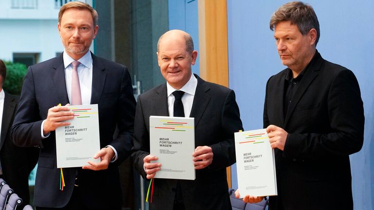 Designated German Chancellor Olaf Scholz, center, designated Finance Minister Christian Lindner, left, and designated Minister for Economics and Climate Protection Robert Habeck, right, present the coalition agreement of their three parties for new German government in Berlin, Germany,