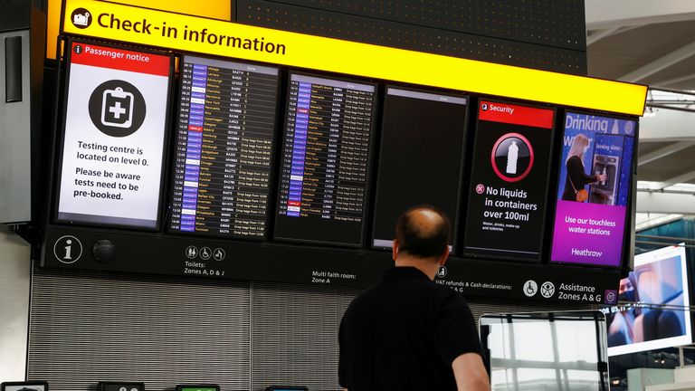 A man looks at a check-in information board in the departures area of Terminal 5 at Heathrow Airport in London, Britain, May 17, 2021. REUTERS/John Sibley/File Photo