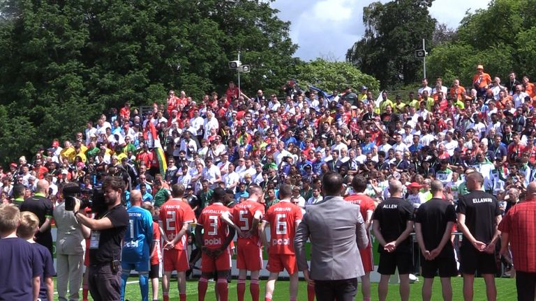 Gales y Dinamarca se alinean para el himno nacional antes del primer partido masculino en la Copa Mundial de Personas sin Hogar 2019 en Cardiff, Gales.