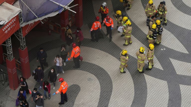 Rescue workers evacuate people from the site after a fire broke out at the World Trade centre in Hong Kong, China, December 15, 2021. REUTERS/Lam Yik
