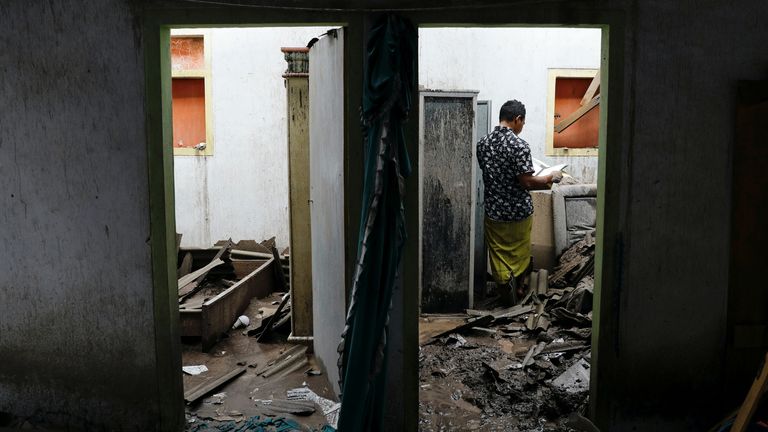 A villager checks the damage to his home following Saturday&#39;s eruption