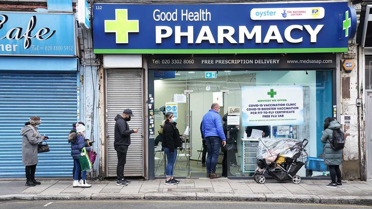 People wait in line to receive a &#39;Jingle Jab&#39; Covid vaccination booster injection at the Good Health Pharmacy, north London, as the coronavirus booster programme continues across the UK on Christmas day. Picture date: Thursday December 23, 2021.