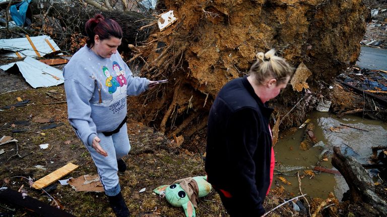Amy Meno and Brooklyn Rogers search for belongings in Earlington, Kentucky