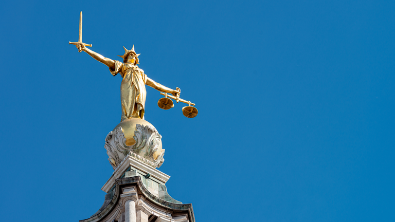 A statue of Lady Justice holding a sword and balancing scales, on top of the Old Bailey, England&#39;s criminal court in the City of London, officially called the Central Criminal Court.

