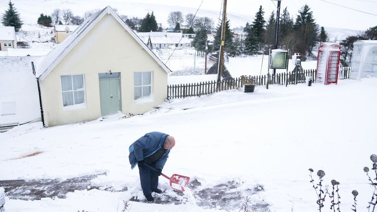 A man clears the snow in Leadhills, South Lanarkshire as Storm Barra hits the UK