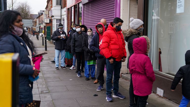 People queue at Melton Road Vaccination Centre in Leicester, as the coronavirus booster vaccination programme is ramped up to an unprecedented pace of delivery, with every eligible adult in England being offered a top-up injection by the end of December. Picture date: Monday December 20, 2021.
