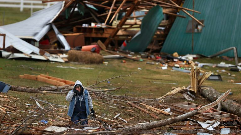 A woman searches for valuables amidst the remnants of a home on Highway F in Defiance, Missouri. Pic: AP