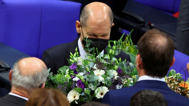 Newly elected German Chancellor Olaf Scholz receives flowers during a session of the German lower house of parliament Bundestag to elect a new chancellor, in Berlin, Germany, December 8, 2021. REUTERS/Fabrizio Bensch
