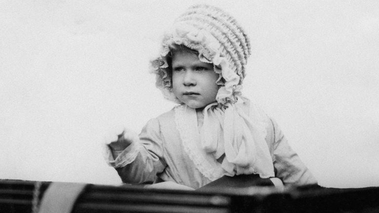 Princess Elizabeth waves from a carriage in 1928