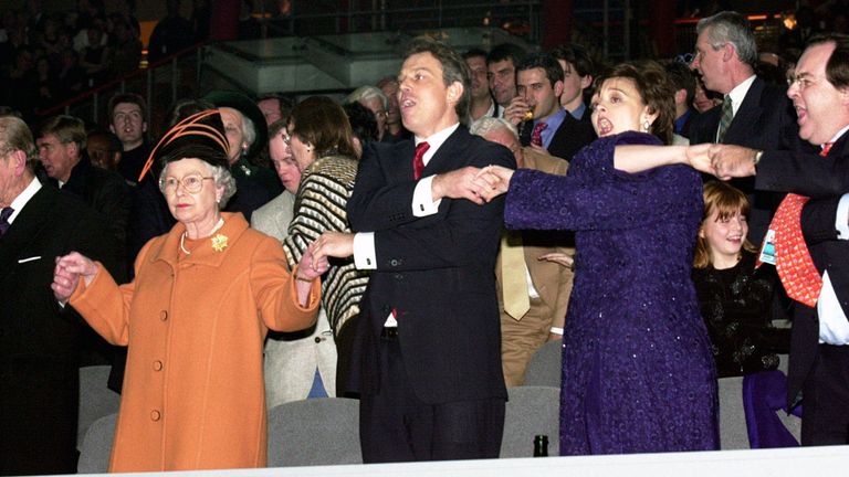 The Queen joins Prime Minister Tony Blair and wife Cherie, singing &#39;Auld Lang Syne&#39; during midnight celebrations to welcome in the new year at the Millennium Dome.