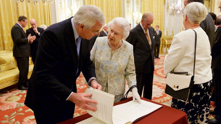 Britain&#39;s Queen Elizabeth and former British prime minister John Major (L) inspect a book during a reception for The Queen Elizabeth Diamond Jubilee Trust at Buckingham Palace in London October 23, 2013. REUTERS/Andrew Matthews/Pool (BRITAIN - Tags: ROYALS)