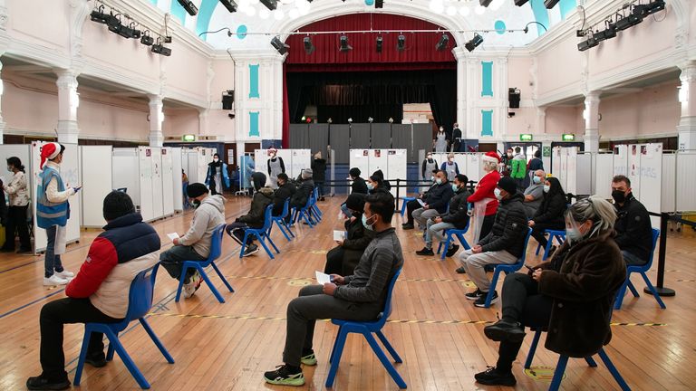 People wait in turn to receive a &#39;Jingle Jab&#39; Covid vaccination booster injection at Redbridge Town Hall, in Ilford, Essex, as the coronavirus booster programme continues across the UK on Christmas day. Picture date: Thursday December 23, 2021.
