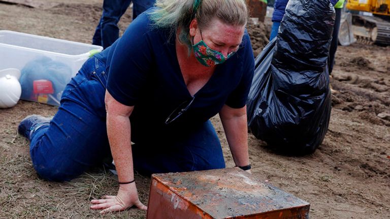 Katherine Ridgway, state archaeological conservator, prepares to wrap and remove a copper box believed to be the 1887 time capsule that was put under the Robert E. Lee pedestal on Monday, December 27, 2021. In back, Everett Mercer, 10, son of Governor Ralph Northam&#39;s chief staff Clark Mercer, stands by to help.  (Eva Russo/ Richmond Times-Dispatch via AP)