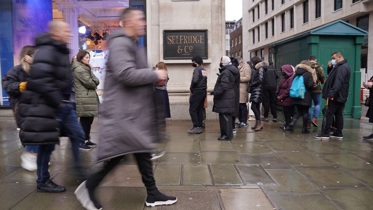 Shoppers stand in line for the doors to open for the start of the Boxing Day sales at Selfridges department store on Oxford Street in London. Consumers are set to shop from home but spend more in the post-Christmas sales than in previous years in a reassuring sign for online retailers, a survey suggests. Picture date: Sunday December 26, 2021.
