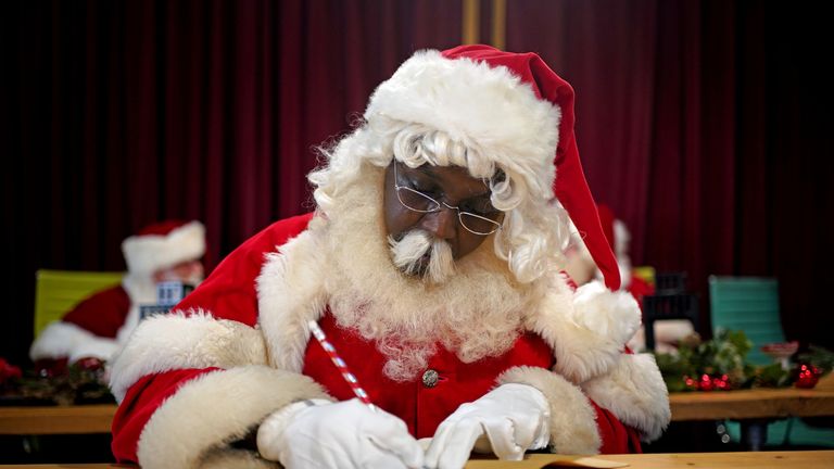 A student santa checks a list as the annual Santa school returns for in person training at the Ministry of Fun&#39;s Santa School in London. Picture date: Tuesday November 30, 2021.

