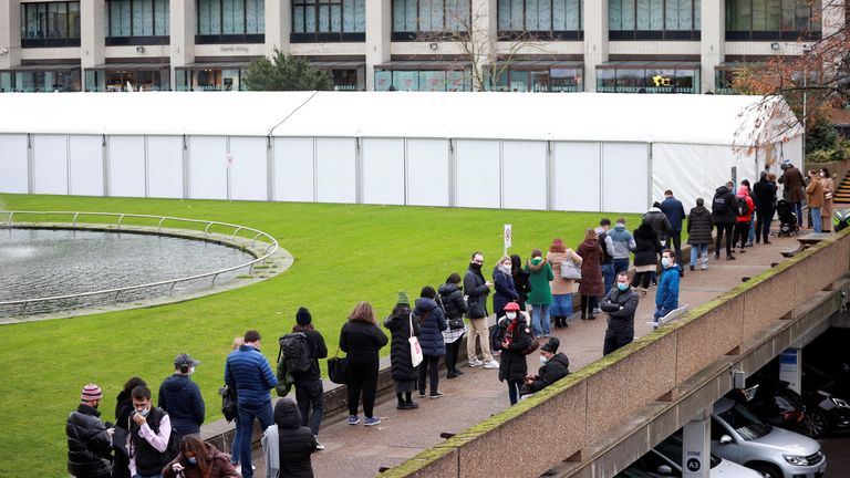 People queue outside a coronavirus disease (COVID-19) vaccination centre at St Thomas&#39;s Hospital in London, Britain, December 13, 2021. REUTERS/Hannah McKay

