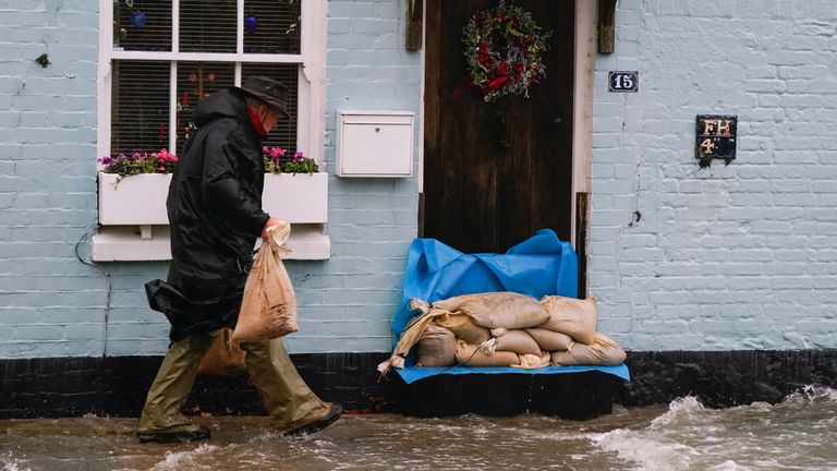 A person places sand bags outside a property in Langstone, Hampshire, as Storm Barra hits the UK and Ireland with disruptive winds, heavy rain and snow on Tuesday. Picture date: Tuesday December 7, 2021.
